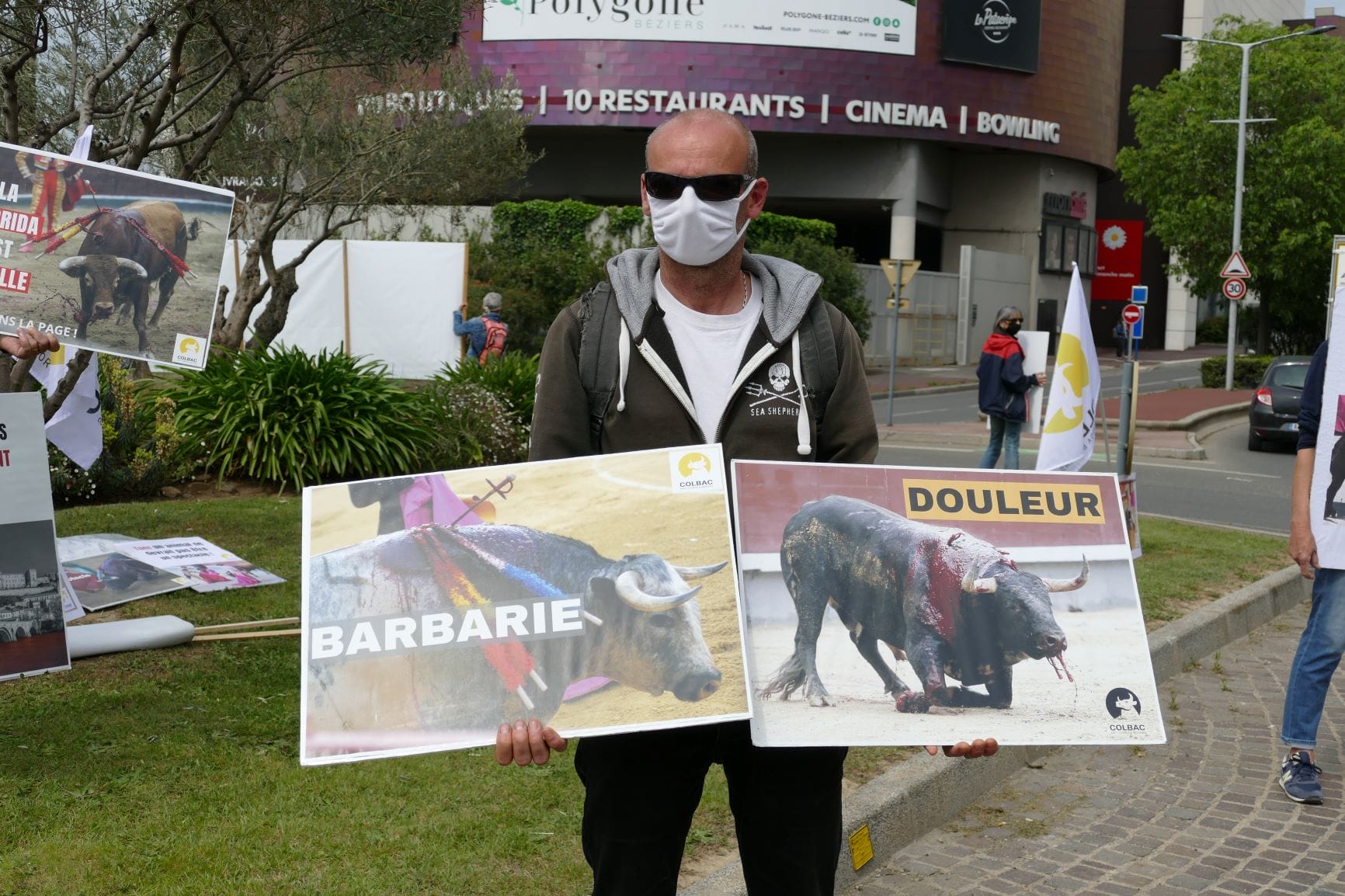 un homme tient 2 pancartes